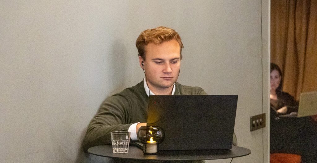 En person sitter vid sin dator och sourcar med hjälp av AI.