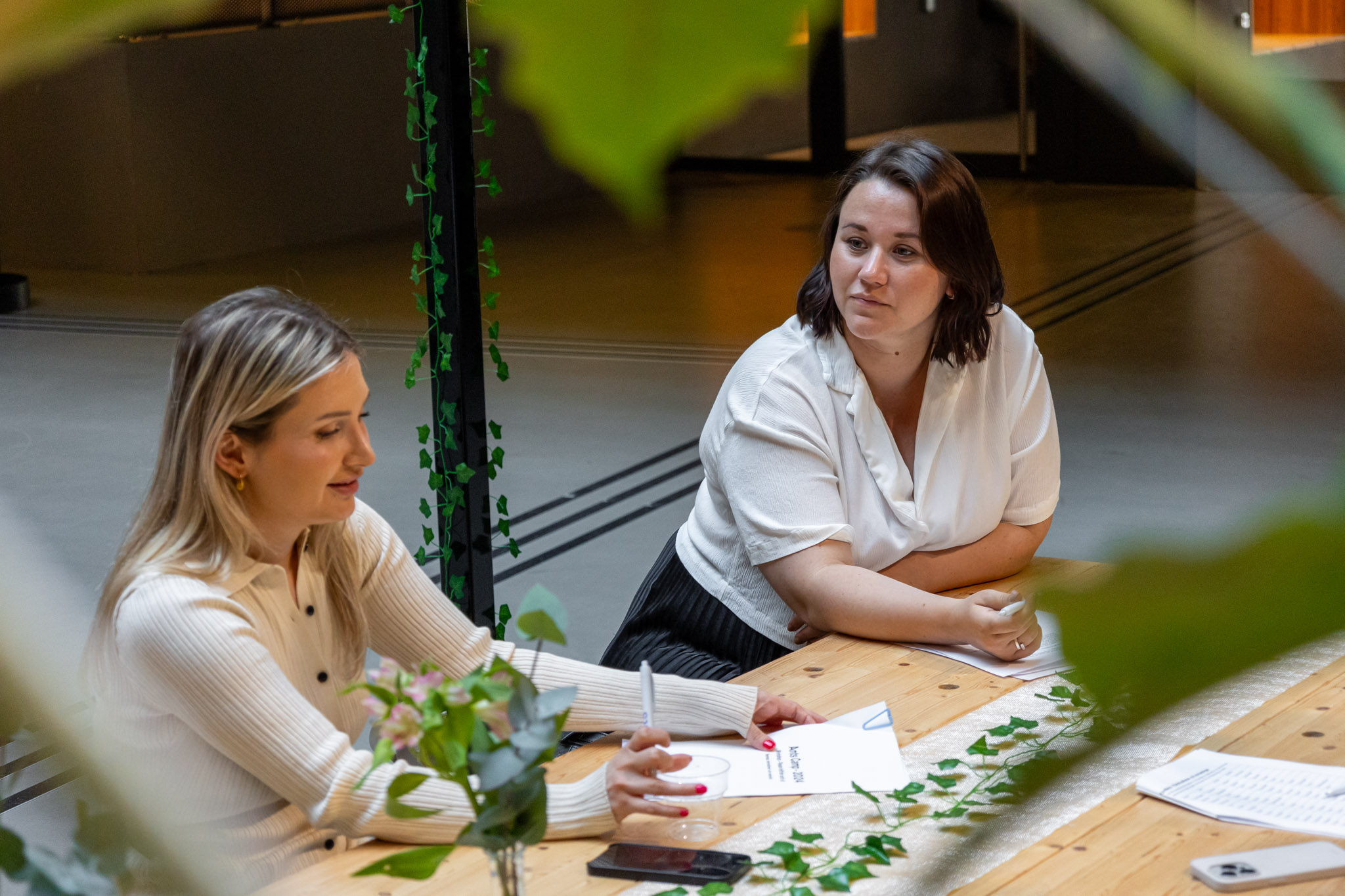 Två personer som sitter vid ett bord och pratar om rollen som Marketing Automation Specialist.