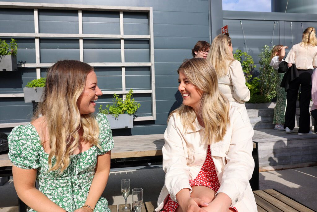 Två personer sitter på en bänk och firar rekryteringen av en Director of Growth.