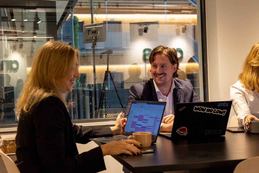 Två personer sitter vid ett bord framför laptops och läser om att rekrytera en Lead Generation Specialist.