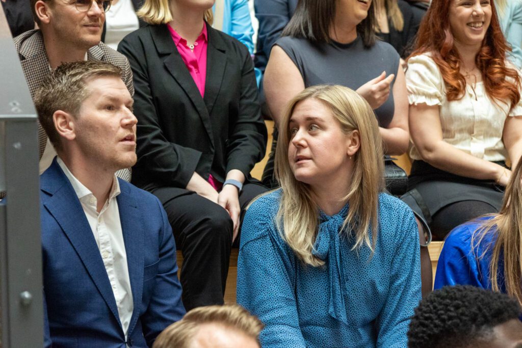 Personer sitter i en trappa och lyssnar på ett föredrag om rollen som Director of Growth.