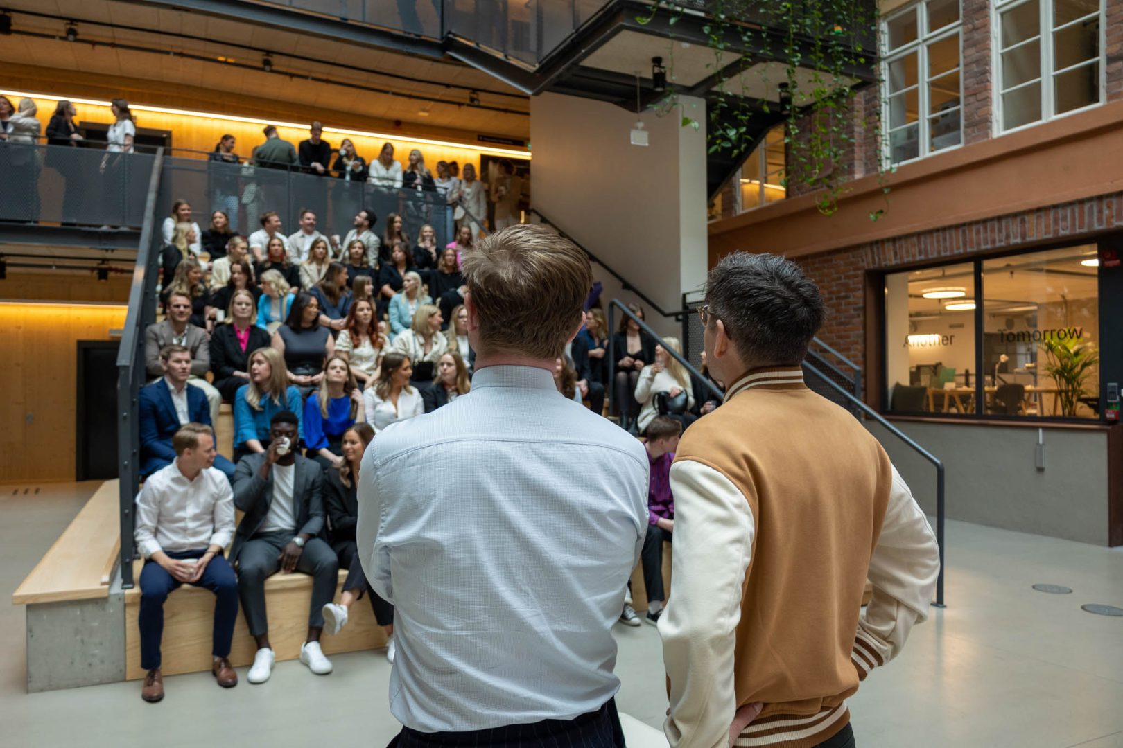 Två personer står framför en grupp människor och pratar om rollen som Global Marketing Manager.