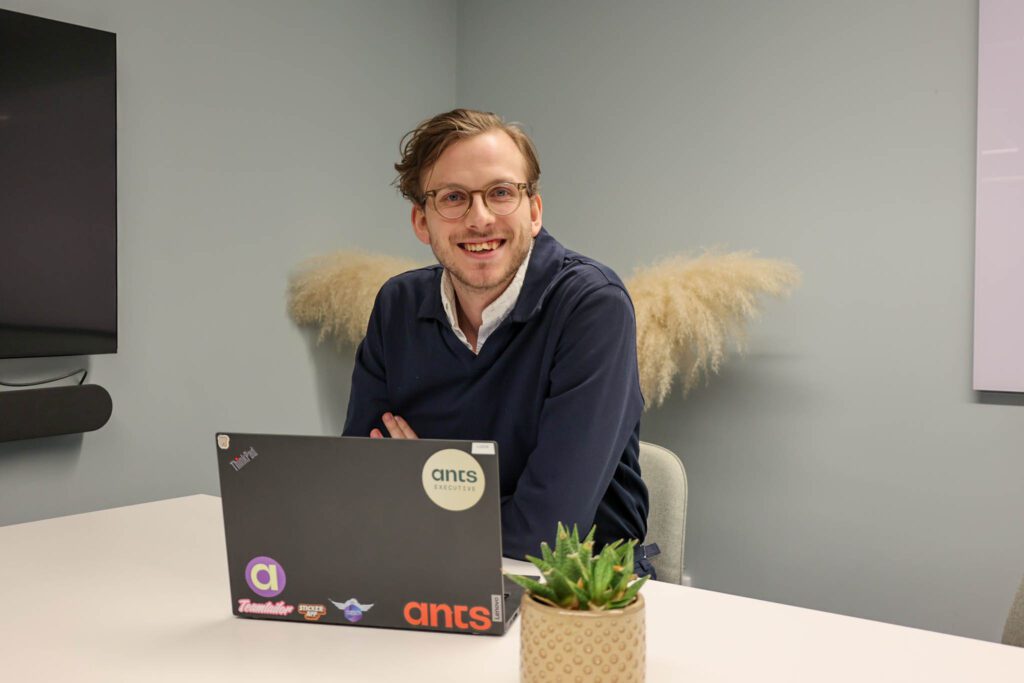 En personer sitter vid ett bord framför en laptop och läser om rollen som Marketing Manager.