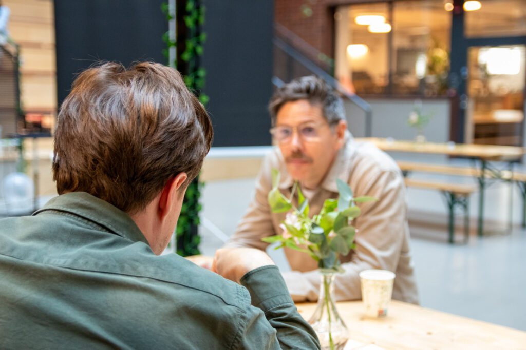 Två personer sitter vid ett bord och pratar om rollen som Director of Digital Marketing.