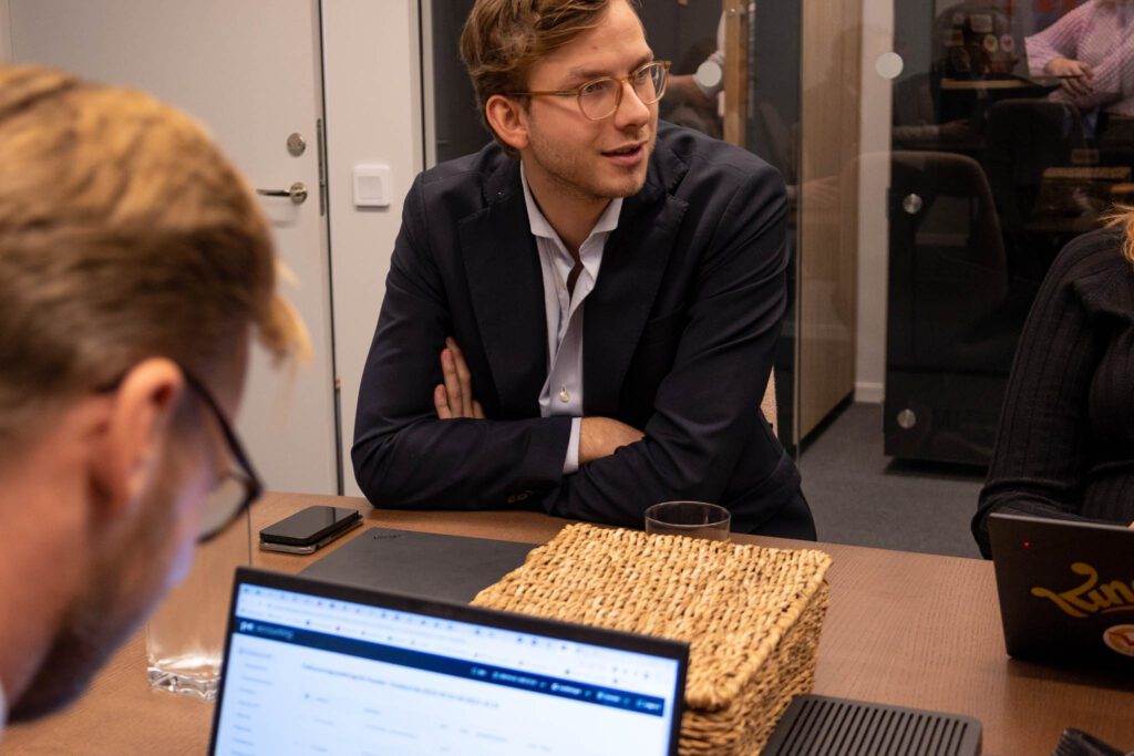 Två personer sitter framför laptops och läser om att rekrytera en Marketing Automation Coordinator.