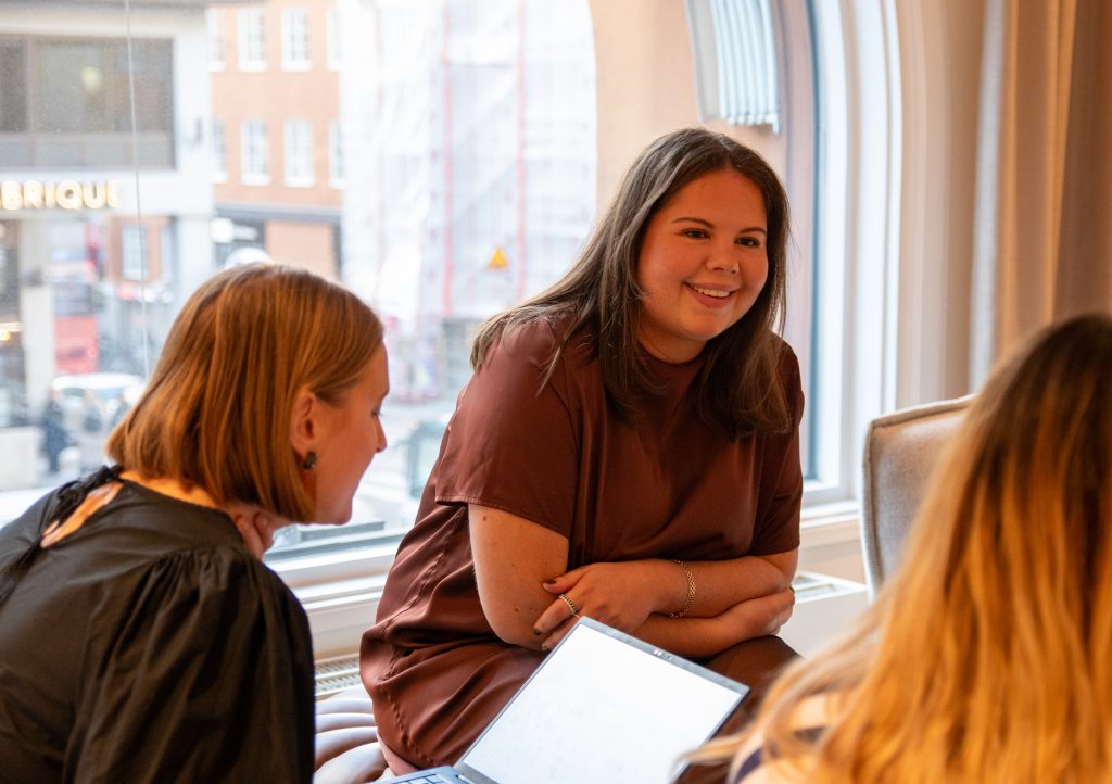 En rekryterare sitter med två andra och samtalar om IT-rekrytering