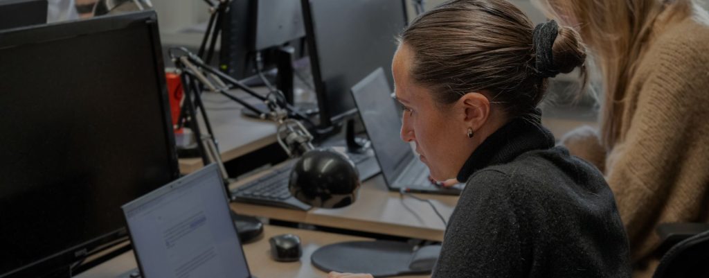 person sitter och jobbar vid sitt skrivbord