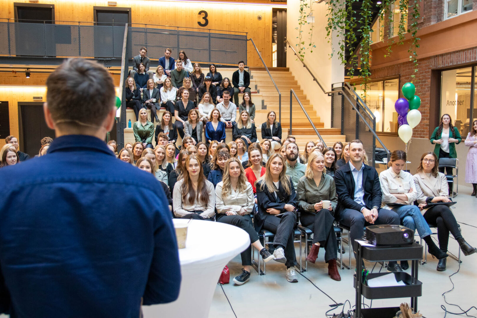 En Chief Gaming Officer håller i ett all-hands möte där framgångar firas och teamet i ett spelutvecklingsföretag delar sina prestationer och strategier för att driva tillväxt samt innovation inom spelutveckling.