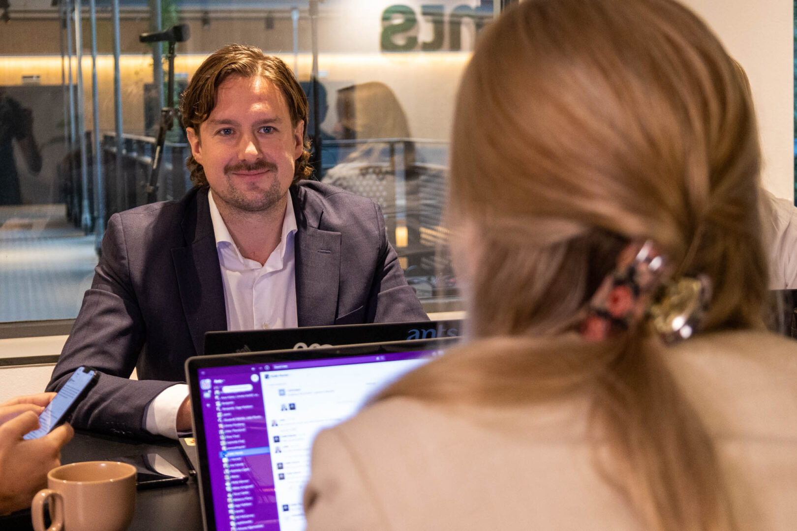 En IAM-analytiker sitter i ett inglasat mötesrum tillsammans med en tekniker, penetrationstestare, third-party risk manager, sårbarhetsanalytiker och incidenthanterare.